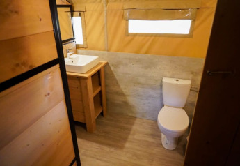 Baño en una tienda safari con inodoro y lavabo en Camping Pittoresque, Francia.