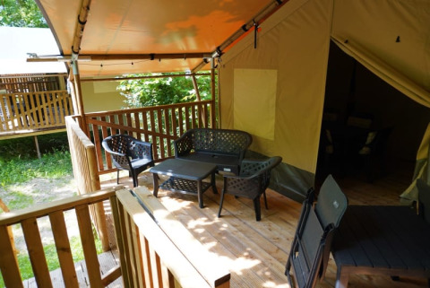 Safari-Zelt mit eigenem Bad auf Camping Pittoresque in Frankreich, Terrasse mit Sitzbereich.