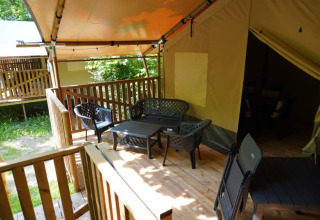 Safari-Zelt mit eigenem Bad auf Camping Pittoresque in Frankreich, Terrasse mit Sitzbereich.