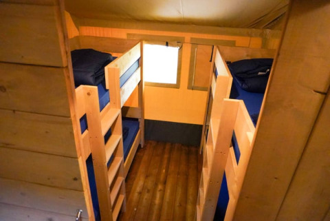 Interiør af Safari telt med to køjesenge og trægulv på Camping Pittoresque i Frankrig.