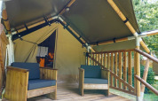 Terraza de madera con dos sillas frente a una tienda safari llamada Duo Lodge en Camping Pittoresque, Francia.