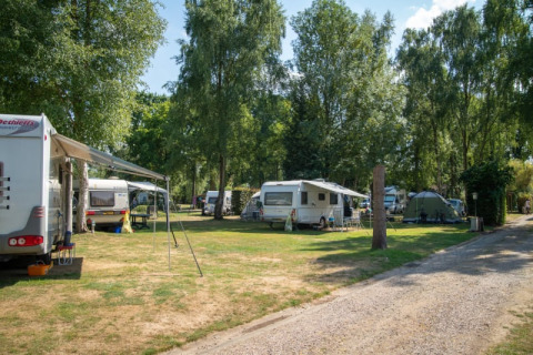 Caravan e tende sotto gli alberi al Safari tent presso Camping Elbeling in Germania in una giornata di sole.