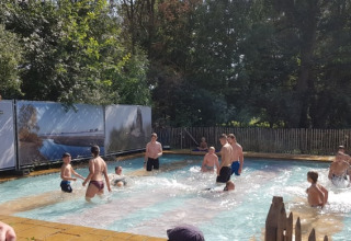 Persone che si divertono in piscina all'aperto vicino alla tenda Safari nel Camping Elbeling, Germania.