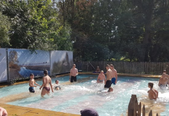 Persone che si divertono in piscina all'aperto vicino alla tenda Safari nel Camping Elbeling, Germania.