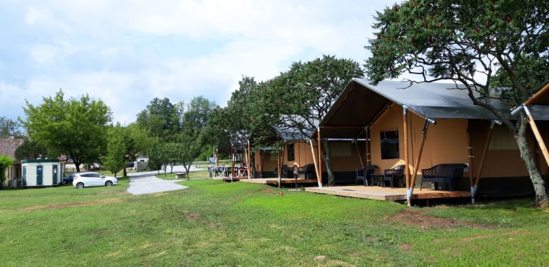 Tentes safari au Camping Prima en République tchèque, avec terrasse en bois et pelouse verdoyante.