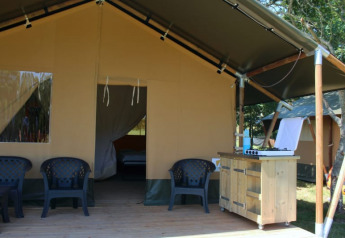 Safari tent at Camping Prima in Czech Republic featuring outdoor seating and a small kitchen area.