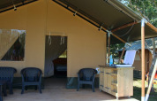 Safari tent at Camping Prima in Czech Republic featuring outdoor seating and a small kitchen area.