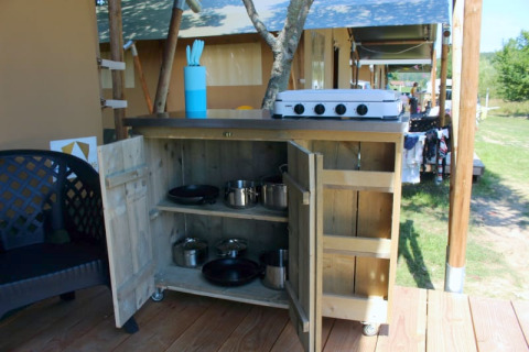 Buitenkitchen aan een safaritent op Camping Prima in Tsjechië met fornuis, potten en keukengerei.
