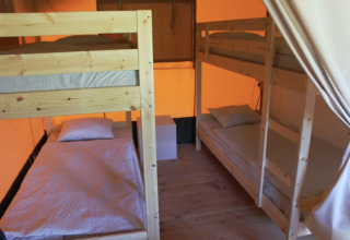 Interno di una tenda safari al Camping Prima in Repubblica Ceca con letti a castello in legno.