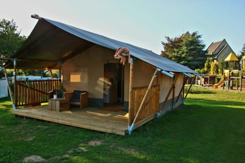 Safari telt med terrasse og bad på Camping La Dolce Vita, Holland, med legeplads i baggrunden.