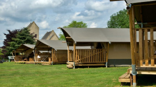 Safari tents with private bathrooms and wooden decks at Camping La Dolce Vita in the Netherlands, outdoors.