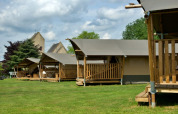 Safari tents with private bathrooms and wooden decks at Camping La Dolce Vita in the Netherlands, outdoors.