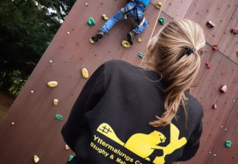 Een vrouw ziet toe op een kind dat klimt aan de safaritent bij Camping Yttermalungs in Zweden.