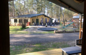 Udsigt fra en safaritelte med egen sanitet på Camping Siësta i Belgien, med legeplads og træer.