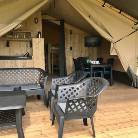 Tienda safari con terraza, zona de estar y cocina en Camping de Zwammenberg, Países Bajos.