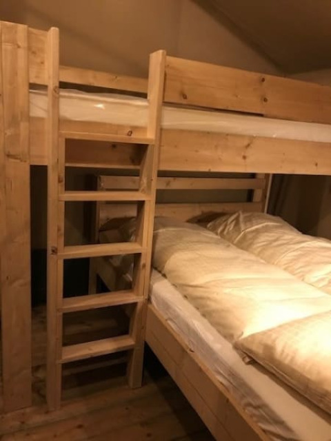 Innenansicht eines Holz-Etagenbettes mit Bettwäsche im Safari-Zelt bei Camping de Zwammenberg, Niederlande.