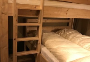 Interno di un letto a castello in legno con biancheria in una tenda safari al Camping de Zwammenberg, Paesi Bassi.
