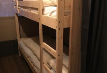 Houten stapelbed in een safari tent met zachte verlichting bij Camping de Zwammenberg in Nederland.