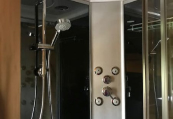 Modern shower cabin with multiple showerheads in Safari tent + sanitary at Camping de Zwammenberg, Netherlands.