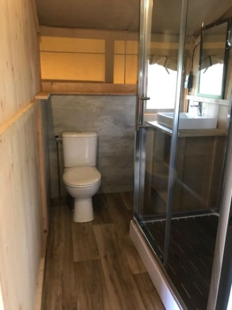 Badezimmer im Safarizelt auf Camping de Zwammenberg mit Toilette, Dusche und Waschbecken.