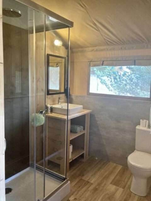 Baño moderno con ducha, lavabo y váter en una tienda safari en el parque Keiheuvel, Bélgica.