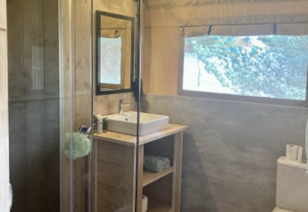 Bagno moderno con doccia, lavandino e WC in una tenda safari al Recreation Park Keiheuvel, Belgio.