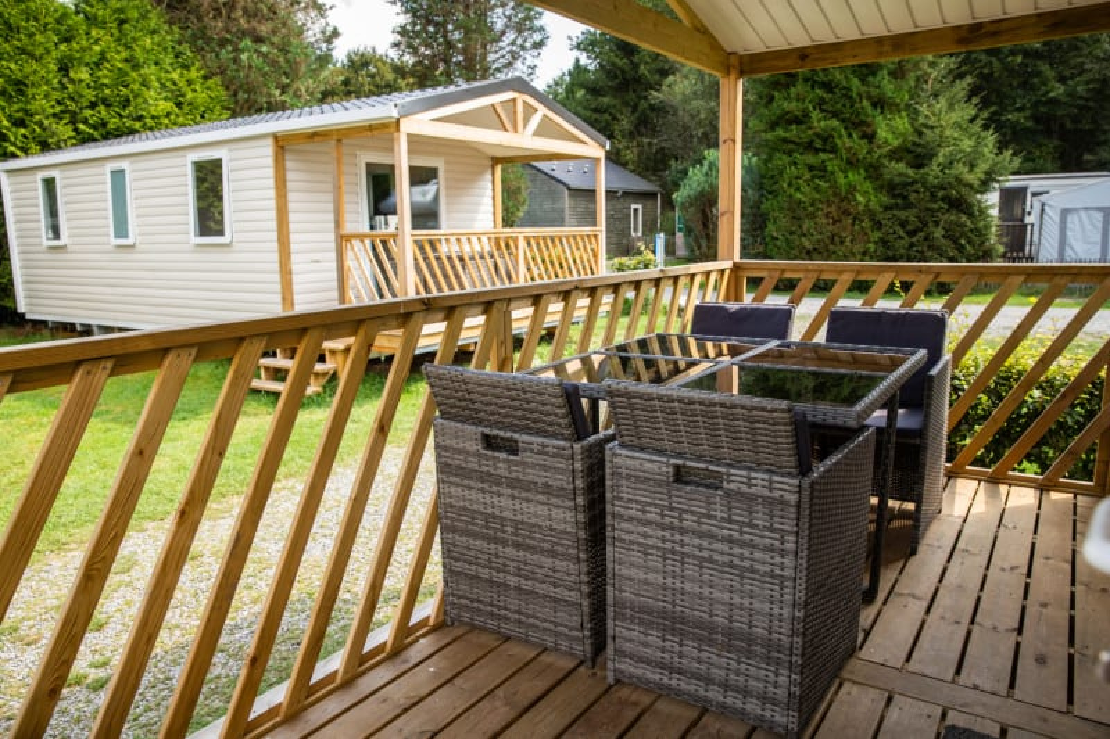 Uitzicht vanaf een houten terras met tuinmeubelen bij Sun Lodge op Camping Les Bouleaux in Frankrijk.