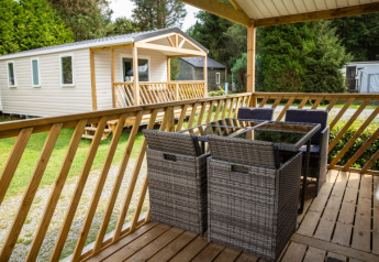 Vista da una terrazza di legno con mobili da esterno presso Sun Lodge al Camping Les Bouleaux in Francia.