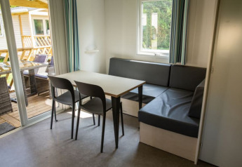 Eethoek met tafel, stoelen en hoekbank in Sun Lodge bij Camping Les Bouleaux, Frankrijk.