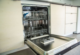Lavastoviglie con sportello aperto in cucina moderna al Sun Lodge di Camping Les Bouleaux in Francia.