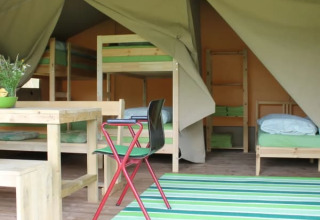 Indretning af Safari-telt med køjesenge, spisebord og grønne accenter på Camping Sretanwolf i Kroatien.