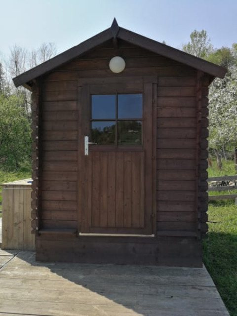 Cabaña de madera con puerta dividida y ventana en Safari tent + sanitary del Camping Sretanwolf, Croacia.