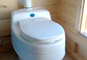 Modern compost toilet in wooden cabin, Safari tent + sanitary at Camping Sretanwolf, Croatia, daylight.