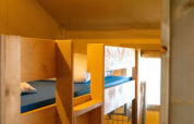 Interior photo of a safari tent with wooden bunk beds at Camping Tussen de Diepen, Netherlands.