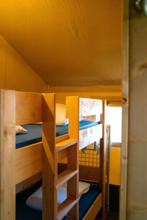 Interieurfoto van een safaritent met houten stapelbedden op Camping Tussen de Diepen, Nederland.