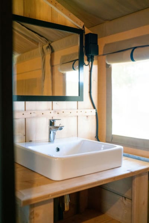 Modernes Waschbecken und Spiegel in einem Safarizelt mit Sanitäranlage auf Camping Tussen de Diepen, Niederlande.