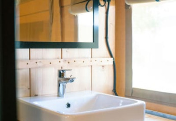 Modernes Waschbecken und Spiegel in einem Safarizelt mit Sanitäranlage auf Camping Tussen de Diepen, Niederlande.