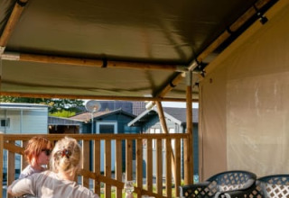 Deux personnes se détendent dans une tente safari avec sanitaires au Camping Tussen de Diepen, Pays-Bas.