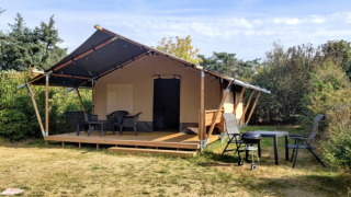 Safari-Zelt auf dem Ballum Campingplatz in Dänemark mit Terrasse, Gartenmöbeln und Umgebung.