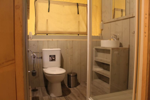 Badezimmer im Safari-Zelt Safari tent + sanitary im Familiepark Goolderheide, Belgien, mit Toilette und Waschbecken.