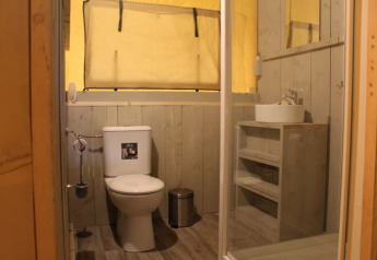 Badezimmer im Safari-Zelt Safari tent + sanitary im Familiepark Goolderheide, Belgien, mit Toilette und Waschbecken.