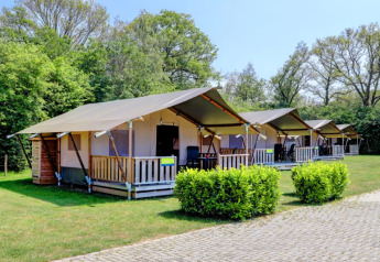 Fila de tiendas safari con veranda y baño privado en Camping Dal van de Mosbeek, Países Bajos.