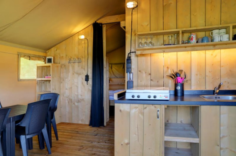 Vue intérieure de la tente Safari avec coin cuisine et salle à manger au Camping Dal van de Mosbeek, Pays-Bas.