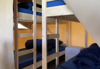 Interior view of a safari tent lodge at Minicamping Falkenborg in the Netherlands with bunk beds.