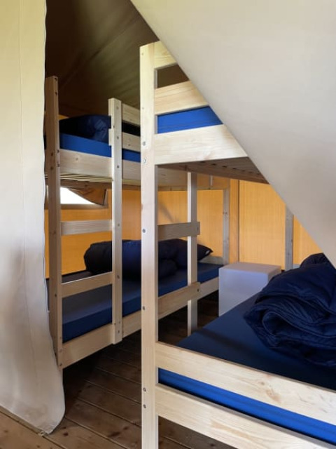 Interior view of a safari tent lodge at Minicamping Falkenborg in the Netherlands with bunk beds.
