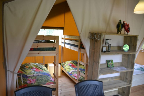 Inside view of a safari tent featuring bunk beds and wooden shelves at Camping Walsheim, Germany.