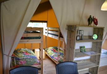 Inside view of a safari tent featuring bunk beds and wooden shelves at Camping Walsheim, Germany.