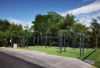 Buiten fitnessruimte in vakantiepark Brinckerduyn in Friesland, Nederland, omgeven door bomen en groen.