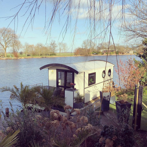 Casa flotante en el parque recreativo y marina Rhederlaagse Meren en los Países Bajos, rodeada de naturaleza.
