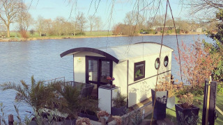 Casa flotante en el parque recreativo y marina Rhederlaagse Meren en los Países Bajos, rodeada de naturaleza.